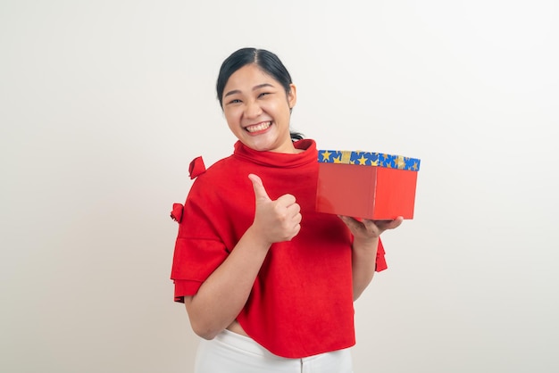 ritratto felice donna asiatica che indossa una camicia rossa con confezione regalo a portata di mano per il festival di Natale