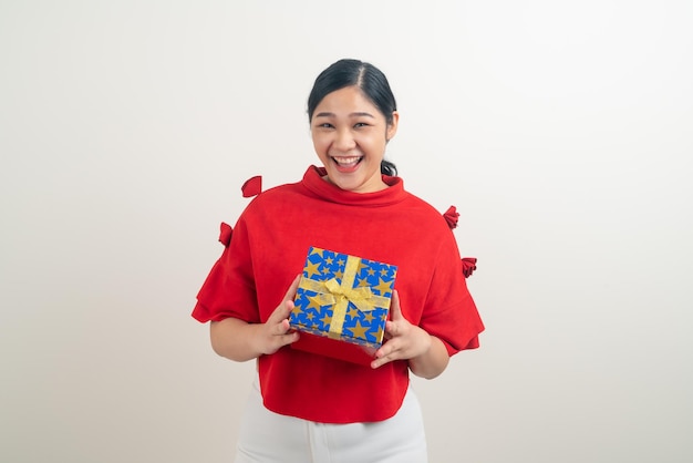 ritratto felice donna asiatica che indossa una camicia rossa con confezione regalo a portata di mano per il festival di Natale
