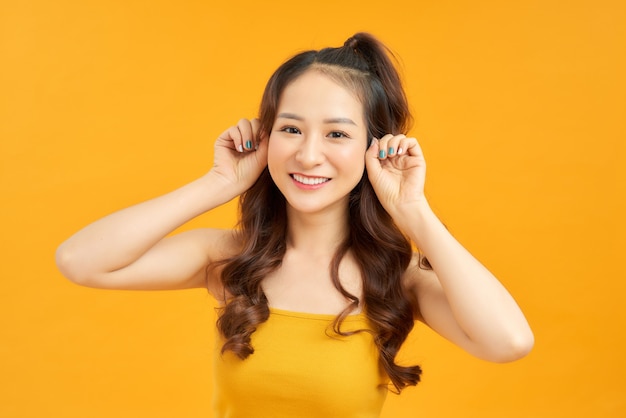 Ritratto felice giovane donna asiatica sentirsi spensierata ridendo emozioni positive su sfondo giallo