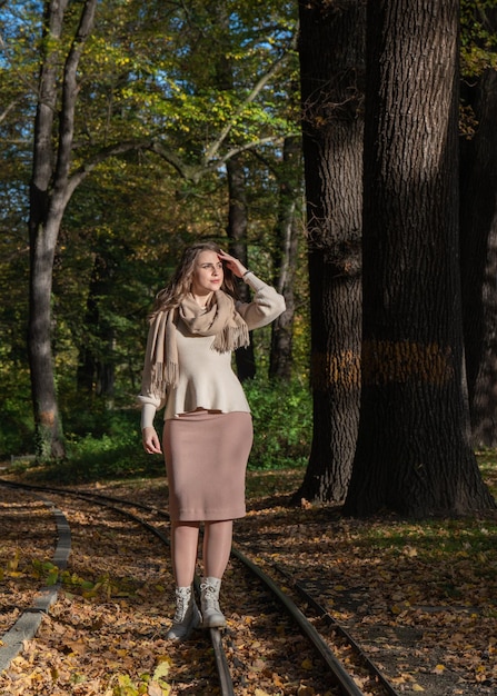 Ritratto femminile Felice bella ragazza si trova sulle rotaie nel parco e distoglie lo sguardo