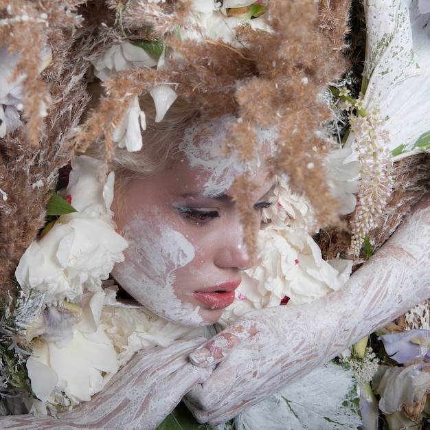 Ritratto femminile in stilizzazione fiaba circondato da piante e fiori naturali.