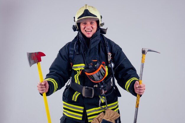 Ritratto forte vigile del fuoco in uniforme ignifuga sfondo bianco studio