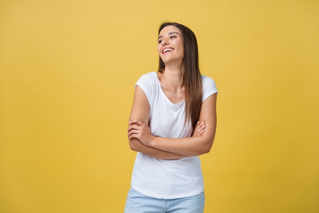 Ritratto giovane bella ragazza caucasica con una camicia bianca ridendo su sfondo giallo.