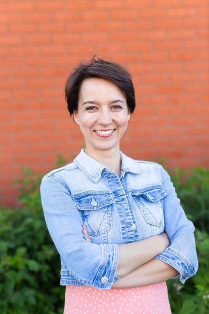 Ritratto Giovane donna allegra che indossa un abito elegante nel patio Ragazza sorridente felice che si diverte all'aperto Bella donna felice che gode dell'estate