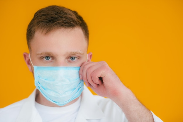 Ritratto giovane medico esausto con maschera medica blu sul viso Prevenzione del coronavirus nCov19