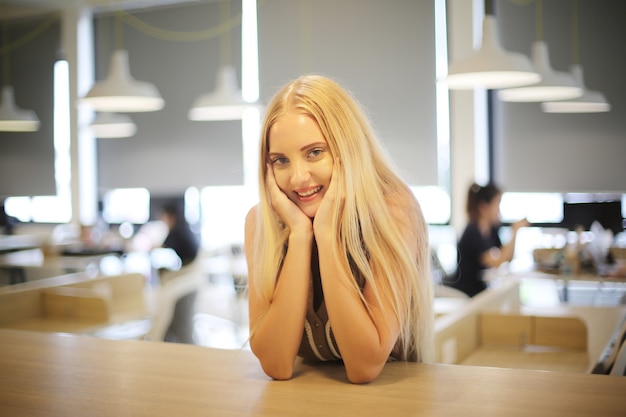 Ritratto giovani belle donne dei capelli biondi che sorridono alla macchina fotografica.