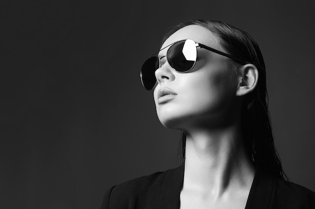 Ritratto in bianco e nero di modo di bella donna sexy in occhiali da sole
