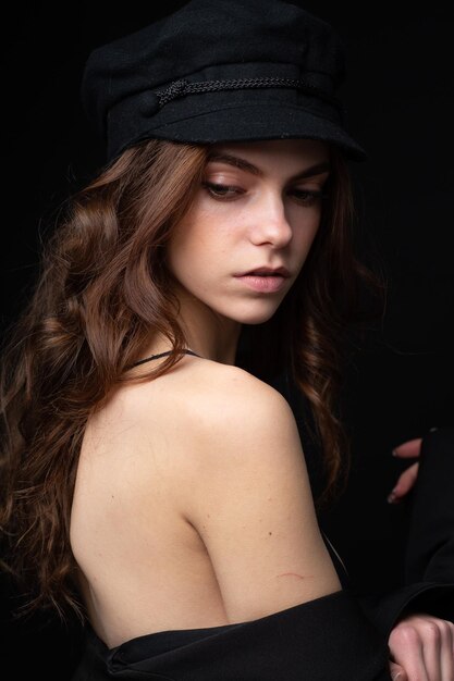 Ritratto in studio alla moda di una bella giovane modella con cappello nero
