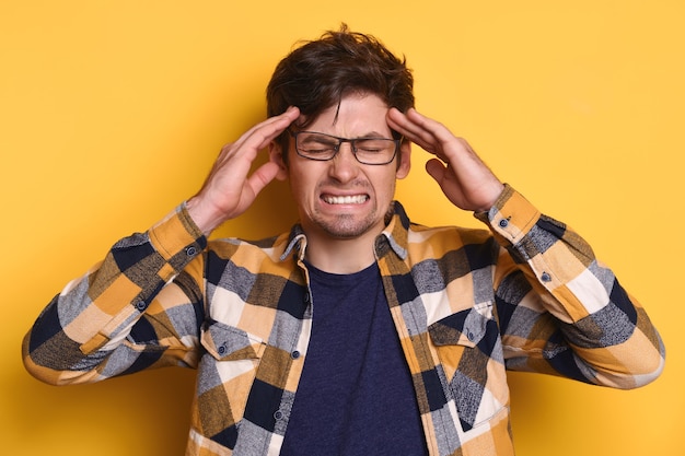 Ritratto in studio di arrabbiato stanco di tutto ciò che l'uomo è furioso, ha mal di testa, stress, superlavoro.