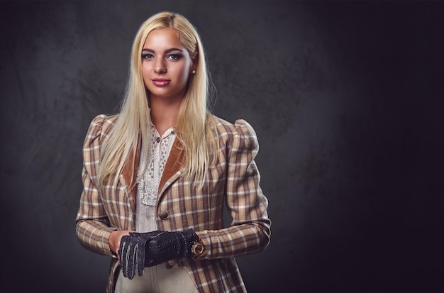 Ritratto in studio di donna bionda vecchio stile su sfondo grigio.