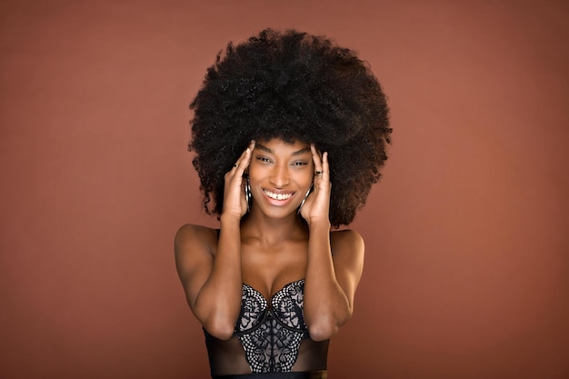 Ritratto in studio di una bella giovane donna dominicana sorridente con l'acconciatura afro