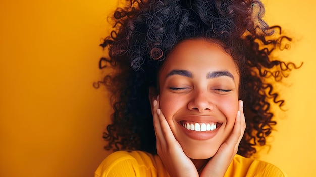 Ritratto in studio di una donna nera che sorride alla telecamera su uno sfondo giallo