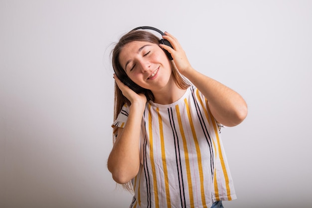 Ritratto in studio di una ragazza spensierata che ascolta musica con le sue cuffie