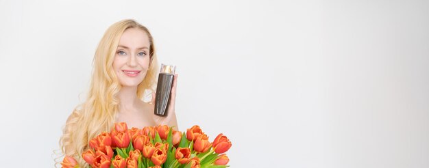 Ritratto in studio splendida donna bionda con lunghi capelli ondulati che tiene bouquet rosso