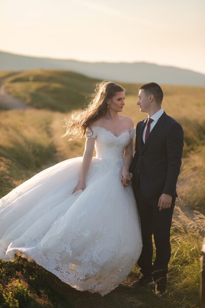 Ritratto integrale del corpo della sposa attraente e dello sposo alla moda che godono di momenti romantici nel