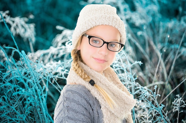 Ritratto invernale di giovane bella ragazza con maglione di lana sciarpa e occhiali