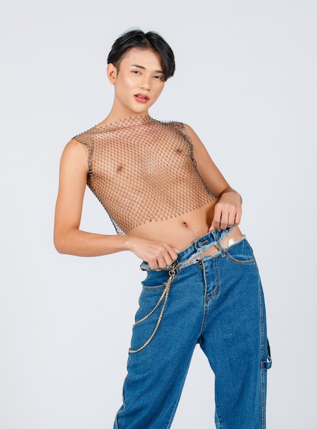 Ritratto isolato ritaglio studio girato asiatico giovane sexy sottile alla moda LGBTQ modello maschio gay in nudo nudo vedere attraverso petto aperto torso rete jeans strappo jeans in piedi in posa su sfondo bianco