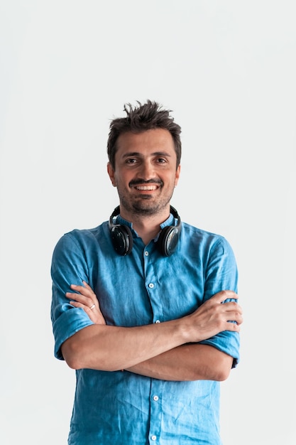 Ritratto maschile d'affari formale. Un uomo d'affari o manager casual di successo sicuro di sé si trova di fronte a uno sfondo bianco, le braccia incrociate, guardando direttamente la telecamera e sorridendo amichevole. Di alta qualità