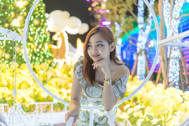 Ritratto notturno di bella donna asiatica La ragazza della Thailandia posa per scattare una foto sulla luce del bokeh di notte