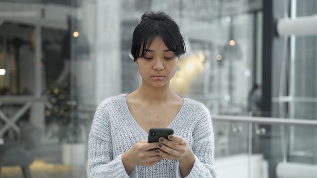 Ritratto palmare di telefono a scorrimento femminile asiatico