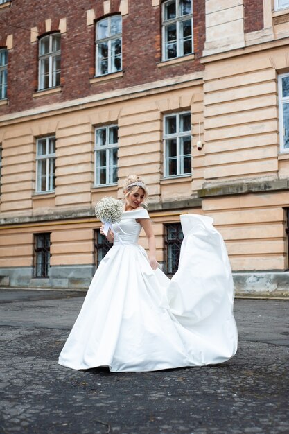 Ritratto perfetto della sposa di una ragazza in un lungo abito bianco