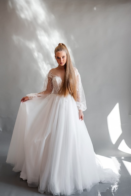 Ritratto perfetto della sposa di una ragazza in un vestito bianco lungo Bei capelli e pelle delicata pulita