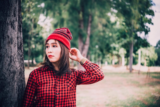 Ritratto ragazza asiatica hipster su sfondo forestalei indossa cappello stile vintageRagazza allegra concetto di modathailandia persone