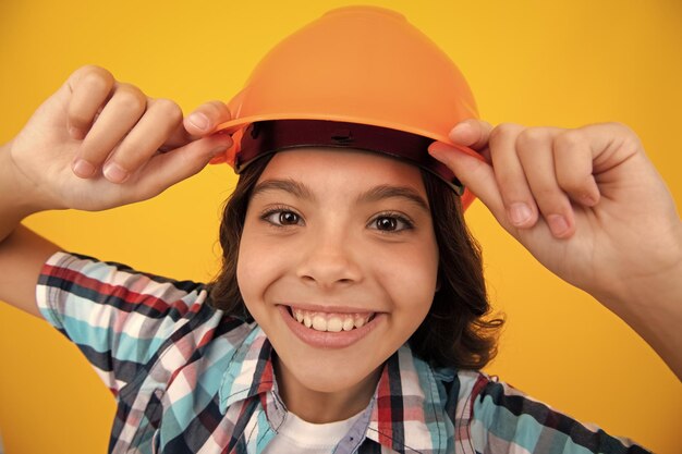 Ritratto ravvicinato del costruttore di bambini nel casco Ragazza adolescente sul lavoro di riparazione isolato su sfondo giallo Concetto di ristrutturazione per bambini