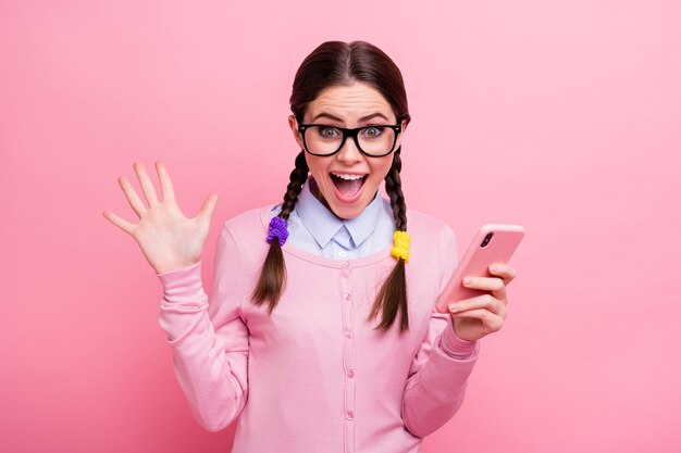 Ritratto ravvicinato di lei attraente piuttosto fortunata estatica pazza felicissima allegra contenta ragazza dai capelli castani geek usando l'app cellulare segui iscriviti ripubblica condividi isolato rosa pastello sfondo di colore