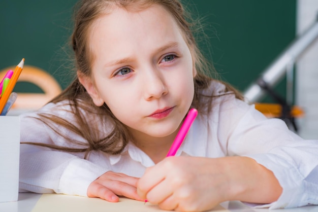 Ritratto ravvicinato di una bambina che disegna con le matite il concetto di educazione e lettura