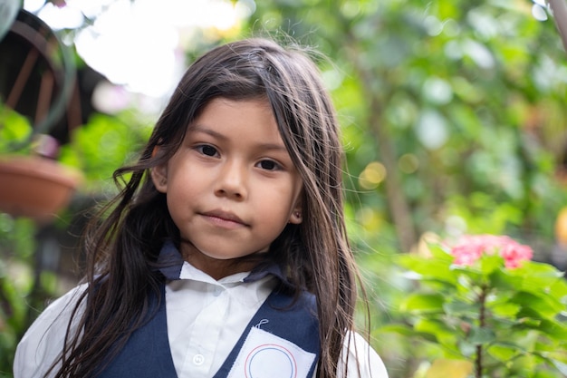 Ritratto ravvicinato di una bambina in uniforme scolastica in piedi guardando la fotocamera