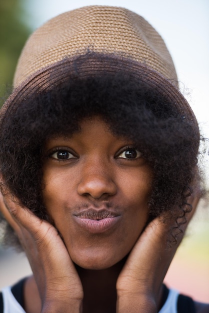 Ritratto ravvicinato di una bella giovane donna afroamericana sorridente e alzando lo sguardo in una bella giornata di sole