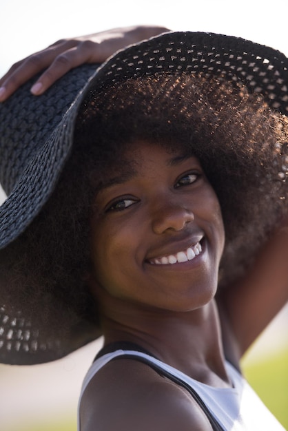 Ritratto ravvicinato di una bella giovane donna afroamericana sorridente e alzando lo sguardo in una bella giornata di sole