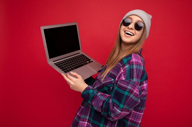 Ritratto ravvicinato di una bella giovane donna che tiene in mano un computer netbook che guarda la telecamera