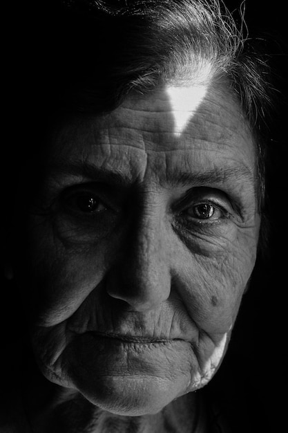 Ritratto ravvicinato di una donna anziana nella camera oscura