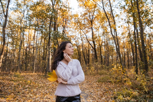 Ritratto ravvicinato di una donna bruna divertente nella foresta autunnale