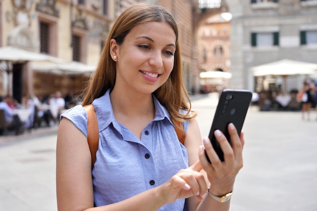 Ritratto ravvicinato di una giovane donna alla moda che tiene in mano uno smartphone