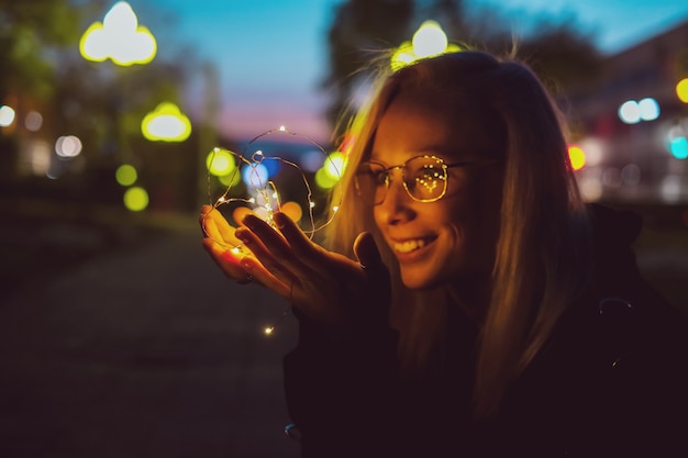 Ritratto romantico di una ragazza con luci sulla strada di notte