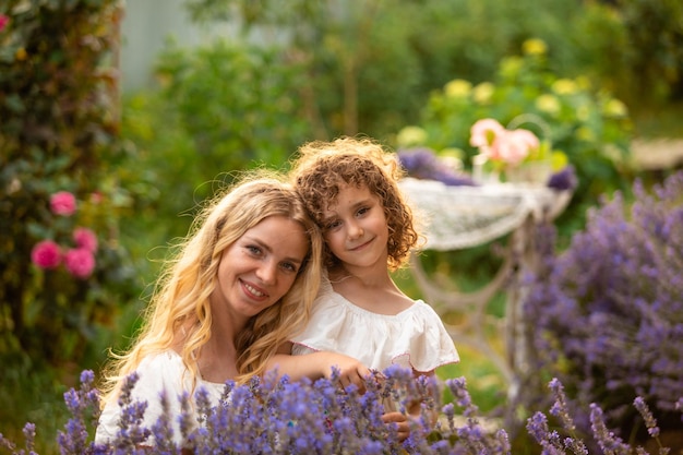 Ritratto romantico o affascinante ragazza con cappello di paglia tra i cespugli di lavanda