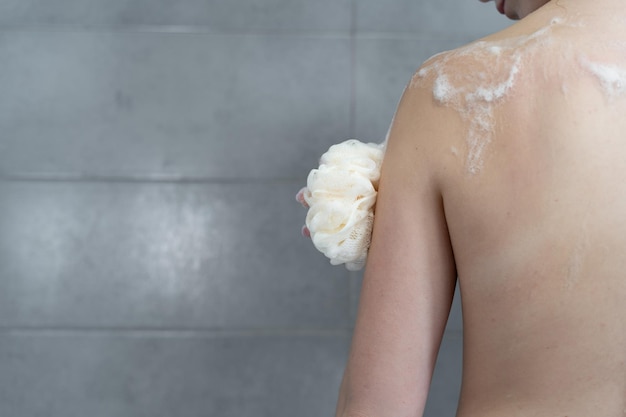 Ritratto sensuale di una giovane donna che fa la doccia Igiene del corpo e della pelle Primo piano di una mano che strofina il corpo con gel o schiuma di shampoo