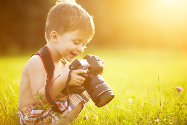 Ritratto soleggiato del bambino con la macchina fotografica