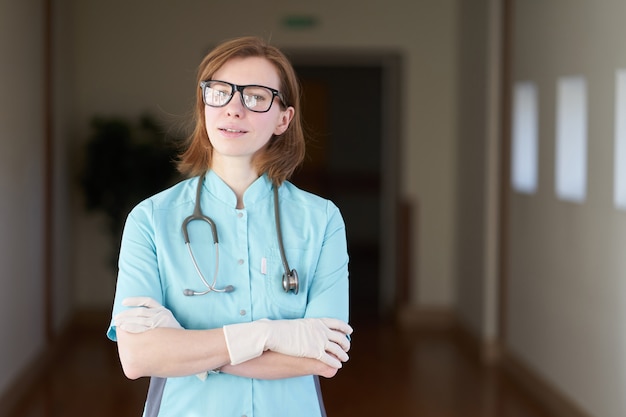 Ritratto sorridente del medico bianco della donna di redhead con lo stetoscopio sul collo