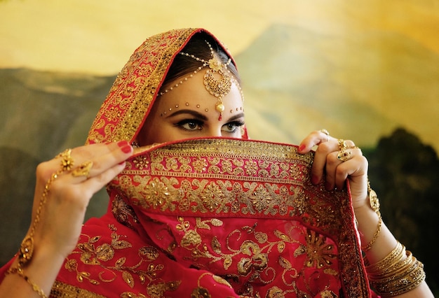 Ritratto sorridente di bella ragazza indiana a casa Modello di giovane donna con set di gioielli d'oro