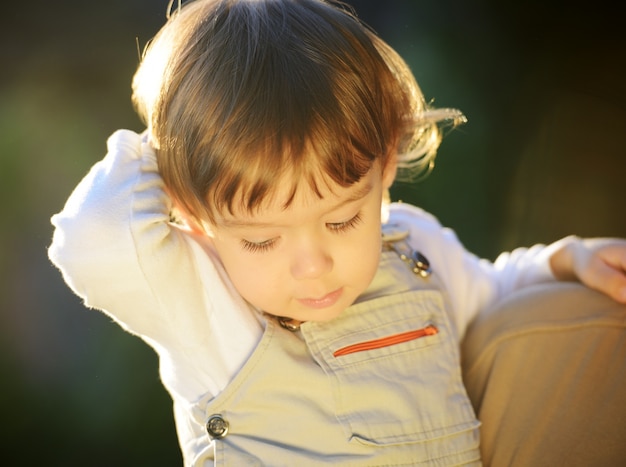 Ritratto sorridente sveglio del bambino fuori nel parco di estate