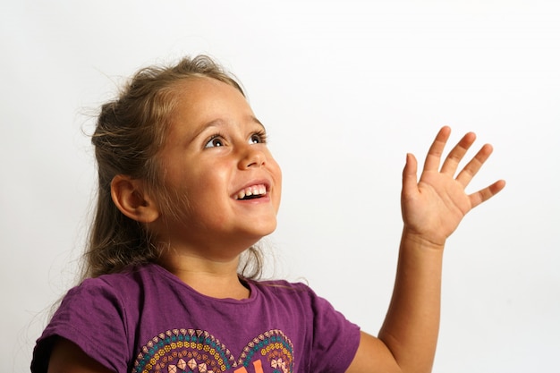 Ritratto su sfondo bianco di una ragazza italiana di 4 anni guardando in alto