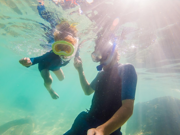 Ritratto subacqueo di padre e figlio che fanno snorkeling insieme