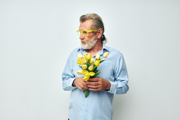 Ritratto uomo anziano giallo bouquet di fiori in posa sfondo isolato