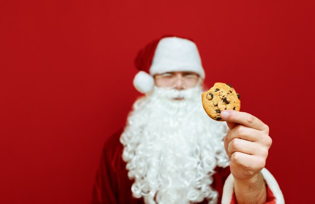 ritratto uomo vestito da Babbo Natale con biscotti al cioccolato