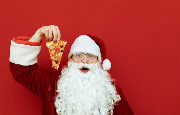 Ritratto uomo vestito da Babbo Natale tenendo la pizza