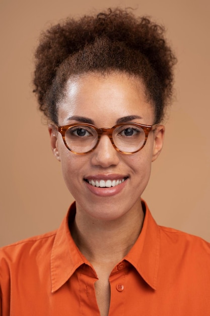 Ritratto verticale di una donna afroamericana sorridente con gli occhiali che sorride alla telecamera
